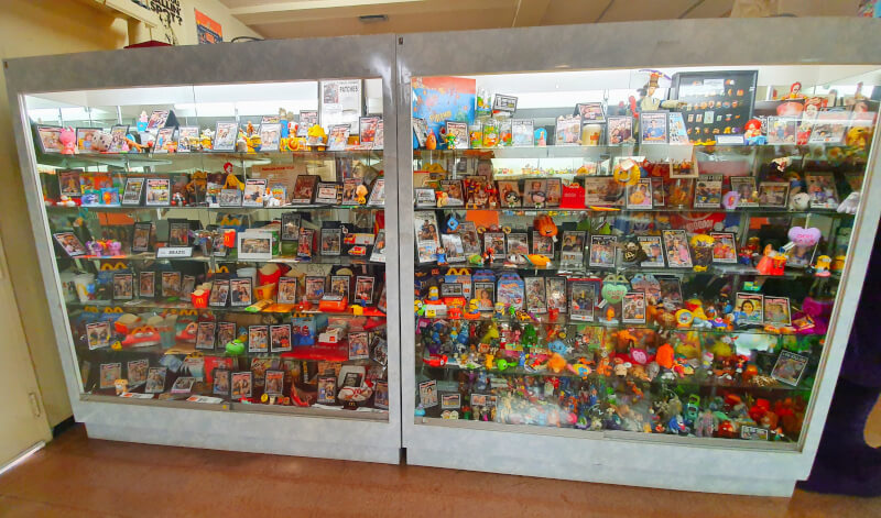 Prateleira com objetos doados por viajantes brasileiros no McDonalds Museum na Rota 66 – Super Viajantes.